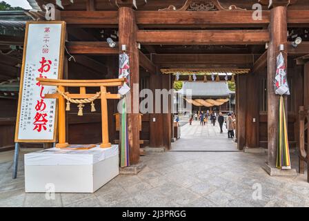 kyushu, giappone - dicembre 08 2021: Riproduzione in miniatura di legno di un cancello torii adornato con decorazioni sacre shinto fatto di paglia secca chiamato Shimenawa Foto Stock