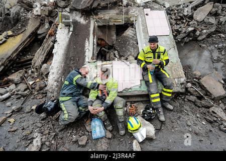 9 aprile 2022, Borodyanka di Buca Raion, Kiev Oblast, Ucraina: Gli addetti alla ricerca e al salvataggio riposano sul relitto di un edificio residenziale danneggiato dallo sciopero aereo russo, mentre continuano a cercare corpi sepolti sotto il relitto, in mezzo all'invasione russa. (Credit Image: © Daniel Ceng Shou-Yi/ZUMA Press Wire) Foto Stock