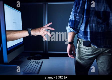 Nessuno è al sicuro dal cyber crimine. Scatto ritagliato di una mano irriconoscibile hacker maschio che si raggiunge da uno schermo del computer. Foto Stock