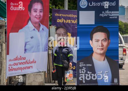 Bangkok, Tailandia. 30th Mar 2022. Un pedone passa accanto ai poster della campagna elettorale del governatore di Bangkok che mostrano i candidati Dutsanee Tiandech, Aswin Kwanmuang e Suchatvee Suwansawat durante i preparativi per le prossime elezioni gubernatoriali e consiglieri della città di Bangkok a Bangkok. L'undicesima elezione del governatorato di Bangkok si terrà il 22 maggio 2022, che è la prima elezione del governatorato di Bangkok in nove anni dal 2013, dopo che l'esercito ha conquistato il potere in un colpo di stato del 2014. (Credit Image: © Peerapon Boonyakiat/SOPA Images via ZUMA Press Wire) Foto Stock