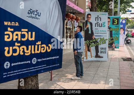 Bangkok, Tailandia. 7th Apr 2022. Un pedone si trova accanto a un poster della campagna elettorale del governatore di Bangkok che mostra il candidato Aswin Kwanmuang durante i preparativi per le prossime elezioni gubernatoriali e consiglieri della città di Bangkok. L'undicesima elezione del governatorato di Bangkok si terrà il 22 maggio 2022, che è la prima elezione del governatorato di Bangkok in nove anni dal 2013, dopo che l'esercito ha conquistato il potere in un colpo di stato del 2014. (Credit Image: © Peerapon Boonyakiat/SOPA Images via ZUMA Press Wire) Foto Stock