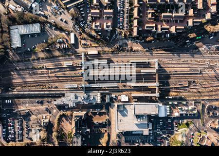 Una vista aerea dall'alto verso il basso dei binari e delle piattaforme della stazione ferroviaria di Peterborough e della zona circostante della città Foto Stock