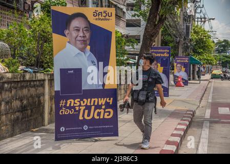 Bangkok, Tailandia. 30th Mar 2022. Un pedone passa accanto a un poster della campagna elettorale del governatore di Bangkok che mostra il candidato indipendente e l'ex governatore di Bangkok Aswin Kwanmuang durante i preparativi per le prossime elezioni gubernatoriali e consiglieri della città di Bangkok. L'undicesima elezione del governatorato di Bangkok si terrà il 22 maggio 2022, che è la prima elezione del governatorato di Bangkok in nove anni dal 2013, dopo che l'esercito ha conquistato il potere in un colpo di stato del 2014. (Foto di Peerapon Boonyakiat/SOPA Images/Sipa USA) Credit: Sipa USA/Alamy Live News Foto Stock