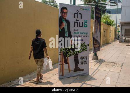 Bangkok, Tailandia. 07th Apr 2022. Un pedone passa accanto a un poster della campagna elettorale del governatore di Bangkok che mostra il candidato Sakontee Pattiyakul durante i preparativi per le imminenti elezioni gubernatoriali e consiglieri della città di Bangkok. L'undicesima elezione del governatorato di Bangkok si terrà il 22 maggio 2022, che è la prima elezione del governatorato di Bangkok in nove anni dal 2013, dopo che l'esercito ha conquistato il potere in un colpo di stato del 2014. (Foto di Peerapon Boonyakiat/SOPA Images/Sipa USA) Credit: Sipa USA/Alamy Live News Foto Stock