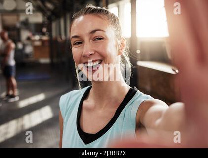 Prendete il selfie, non si sa mai chi youre ispiratore. Scatto di una giovane donna in forma in palestra. Foto Stock