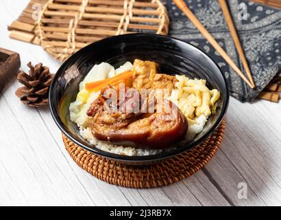 Riso di maiale Knuckle Bento in un piatto isolato su tavola di legno vista laterale taiwan cibo Foto Stock