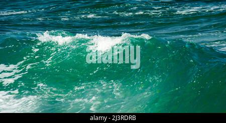 sfondo a onda verde con luce naturale del giorno. acqua sfocata e schiuma Foto Stock