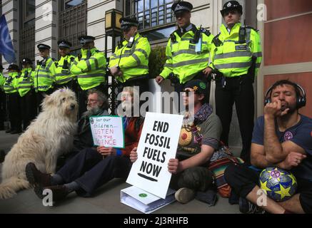 Londra, Regno Unito. 09th Apr 2022. I ribelli siedono di fronte alla linea di polizia, formata come protezione alla sede della BP nel Regno Unito durante la manifestazione. Il giorno di apertura della ribellione primaverile dell'estinzione. I ribelli hanno promesso di causare disagi a Londra fino a quando il governo non ascolta le loro richieste e non riconosce l'emergenza climatica. (Foto di Martin Pope/SOPA Images/Sipa USA) Credit: Sipa USA/Alamy Live News Foto Stock