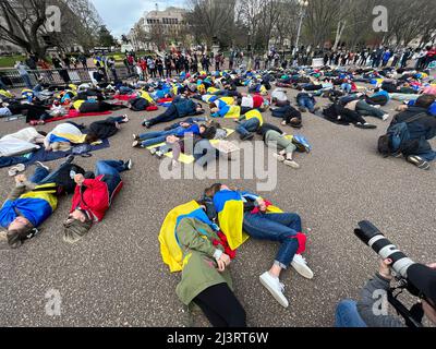 09 aprile 2022 Washington DC USA sostenitori per l'Ucraina dimostrazione di scena di fronte alla Casa Bianca giacente sul terreno per simulare i morti come nomi dei morti erano morti a!oud. Foto Stock