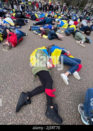 09 aprile 2022 Washington DC USA sostenitori per l'Ucraina dimostrazione di scena di fronte alla Casa Bianca giacente sul terreno per simulare i morti come nomi dei morti erano morti a!oud. Foto Stock