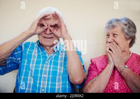 Il tempo ci ha portato tanta felicità. Colpo di una coppia anziana che fa le facce divertenti fuori. Foto Stock