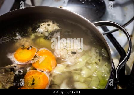 La zuppa viene cucinata in stufa durante la cottura in una pentola grande. Foto Stock