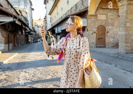 Donna che visita il famoso vecchio ponte, chiamato Ponte Vecchio, a Firenze Foto Stock