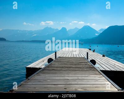 Vista panoramica di un lago australiano con molo in legno e catena montuosa sullo sfondo. Salzkammergut Austria superiore Foto Stock