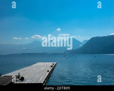 Vista panoramica di un lago australiano con molo in legno e catena montuosa sullo sfondo. Salzkammergut Austria superiore Foto Stock