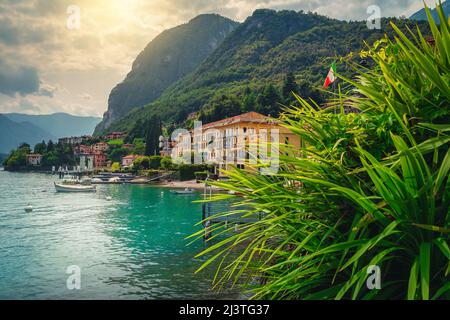 Barche ormeggiate sul lago di Como e colorati edifici sullo sfondo, Menaggio, Lombardia, Italia, Europa Foto Stock