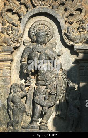 Scultura in pietra della bella femmina (Madanikas) con fuoco selettivo, tempio indù del 12th secolo, arte in pietra antica e sculture in ogni pilastro, che Foto Stock