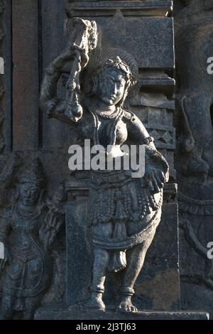 Scultura in pietra della bella femmina (Madanikas) con fuoco selettivo, tempio indù del 12th secolo, arte in pietra antica e sculture in ogni pilastro, che Foto Stock