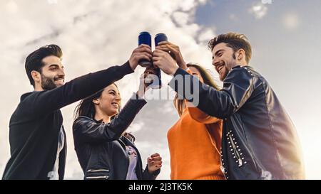 Concetto di stile di vita dei giovani che alzano le mani con le birre in scatola e che si divertono a celebrare insieme la tostatura Foto Stock