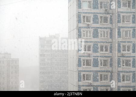 Alti blocchi di appartamenti in un'area residenziale della città in una giornata nuvolosa in una nevicata Foto Stock