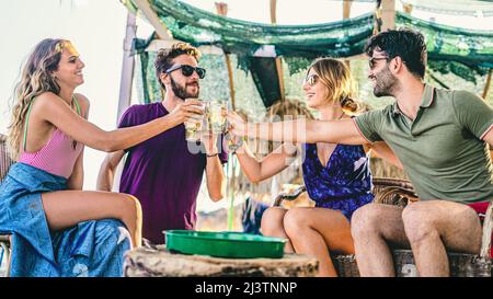 I migliori amici bevono cocktail sulla spiaggia e tostano durante l'happy hour. Foto Stock