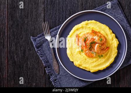 Polenta e schie fritte, piatto veneziano, polenta con gamberi fritti su un piatto su tavola di legno scuro, vista orizzontale dall'alto, piatto, spazio libero Foto Stock