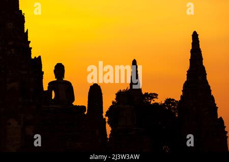 Il paesaggio dell'antico tempio buddista di Wat Chaiwatthanaram al tramonto, l'antica statua del Buddha e la pagoda contro il cielo del tramonto. Ayutthaya. Foto Stock