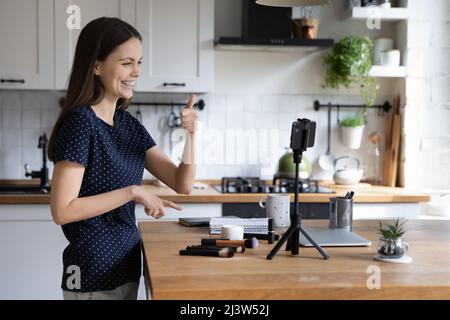 Make up artista che mostra al cellulare fotocamera pollici verso l'alto gesto Foto Stock