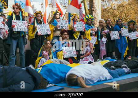 Donne pro-ucraine in una manifestazione a Londra contro la guerra in Russia. Circondato da bandiere ucraine. Striscioni contro il massacro di Bucha. Sdraiato Foto Stock