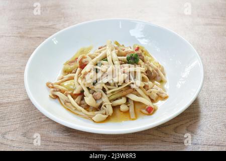 aggiungere il fungo fritto shimeji piccante con tritare il maiale e il pepe sul piatto Foto Stock
