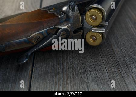 Fucile da caccia e accessori da caccia sul tavolo. Pistola da caccia vintage con cartucce su sfondo in legno. Vista dall'alto. Foto Stock