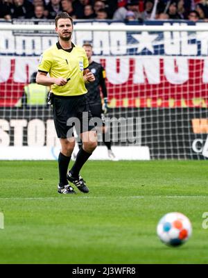Kiel, Germania. 10th Apr 2022. Calcio: 2nd Bundesliga, Holstein Kiel - Hamburger SV, Matchday 29, Holstein Stadium. L'arbitro Daniel Schlager guarda la palla. Credit: Axel Heimken/dpa - NOTA IMPORTANTE: In conformità con i requisiti della DFL Deutsche Fußball Liga e della DFB Deutscher Fußball-Bund, è vietato utilizzare o utilizzare fotografie scattate nello stadio e/o della partita sotto forma di immagini di sequenza e/o serie di foto video-simili./dpa/Alamy Live News Foto Stock