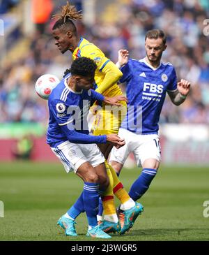 Wilfried Zaha (centro) del Crystal Palace e James Maddison (destra) di Leicester City e James Justin combattono per la palla durante la partita della Premier League al King Power Stadium di Leicester. Data foto: Domenica 10 aprile 2022. Foto Stock