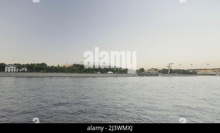 Fiume Mosca, vista dalla nave con effetto time lapse sullo sfondo del cielo del tramonto. Azione. Nave che naviga lungo l'argine della città di Mosca. Foto Stock