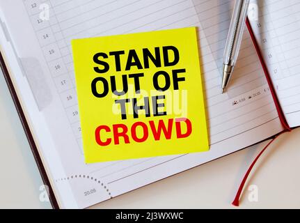 Le parole si levano in piedi dalla folla scritta su un taccuino bianco. Primo piano di un'agenda personale. Foto Stock