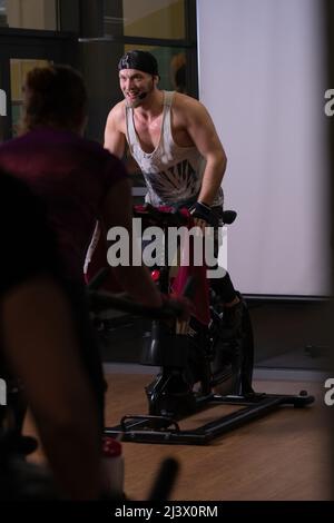 Bicicletta su allenatore bici su pompato un atleta gambe allenamento ginnastica atleta, per i giovani in attivo per la forma bodybuilder, Ay man. Adulta Foto Stock