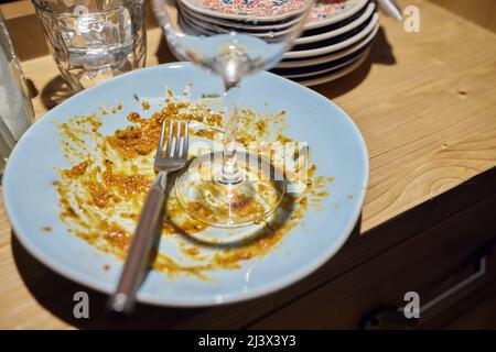 Non finito di mangiare la pasta con salsa di pomodoro in piatto bianco. Oggetto fuori fuoco. Nessuna messa a fuoco. Vista dall'alto, primo piano Foto Stock