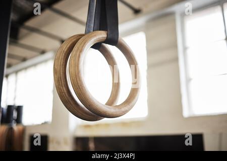 Lascia costruire un po' di muscolo. Foto vita di anelli di ginnastica in una palestra. Foto Stock