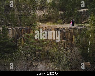 Vista aerea drone viaggio in famiglia, ammirando il paesaggio su colonne basaltiche incredibile paesaggio industriale, lago smeraldo in una cava allagata, opencast min Foto Stock