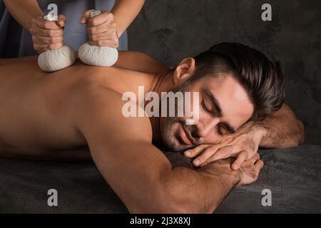 Giovane bell'uomo che ha massaggio alla schiena con pouche Foto Stock