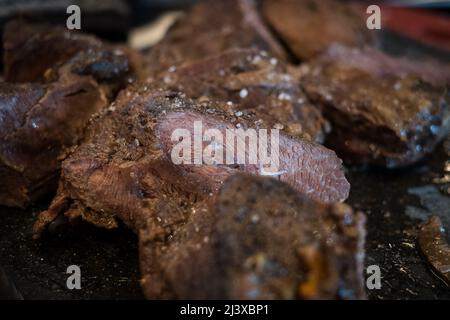 Guance di manzo brasate cotte in salsa di vino rosso sul tagliere. Stufato di carne cotto lento. Foto Stock