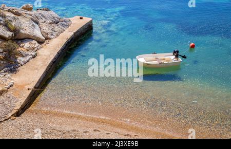 Piccola barca galleggiante nelle acque cristalline del Mar Egeo in Alonnisos Grecia Foto Stock