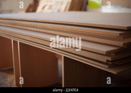 I pannelli sono impilati. Foglio di legno compensato. Falegnameria. Hanno fatto la produzione di mobili. Materiale da costruzione in garage. Legno grezzo. Materiale fatto di segatura pressata. Foto Stock