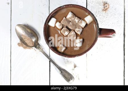 bevanda calda al cioccolato in una tazza di smalto vintage su sfondo di legno Foto Stock