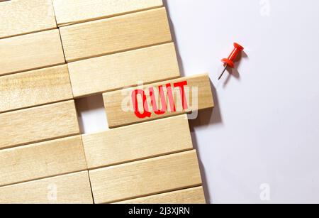 la parola ha rinunciato sui cubi di legno sullo sfondo di un uomo in un vestito. Foto Stock