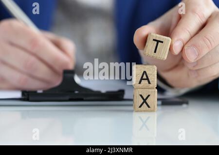 La persona compila il modulo fiscale in primo piano Foto Stock