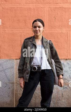 Giovane viaggiatore misto con abbigliamento casual e macchina fotografica all'aperto. Turismo e concetto di viaggio. Foto Stock