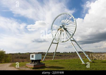 Newcastle-under-Lyme, Staffordshire, 04,08.2022, Apedale pit wheel memoriale e vasca di carbone situato nel parco comunale di Apedale, ex miniera di opencast Foto Stock