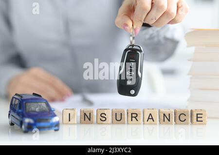 L'agente detiene le chiavi per l'auto e iscrizione assicurazione primo piano Foto Stock