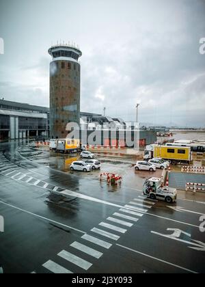 El Prat de Llobregat, Barcellona, Spagna - 13 marzo 2022: Una torre di controllo e veicoli circolanti all'aeroporto di Barcellona. Foto Stock